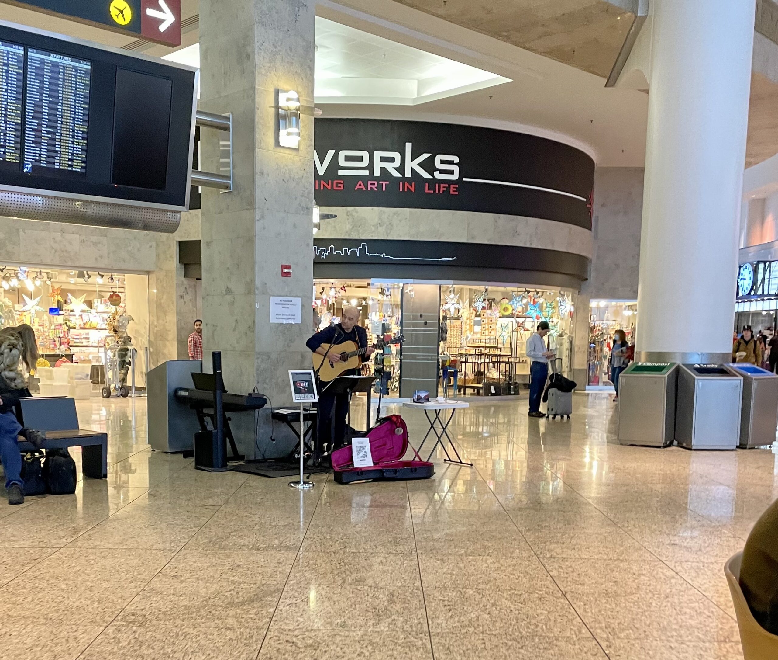 Performer plays the guitar at Sea-Tac airport